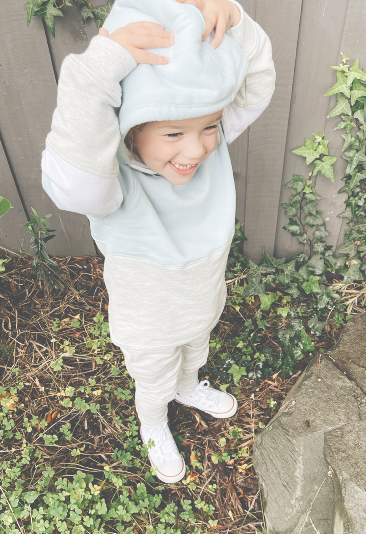 little girl smiling with hooded jumper and matching tracksuit pant on