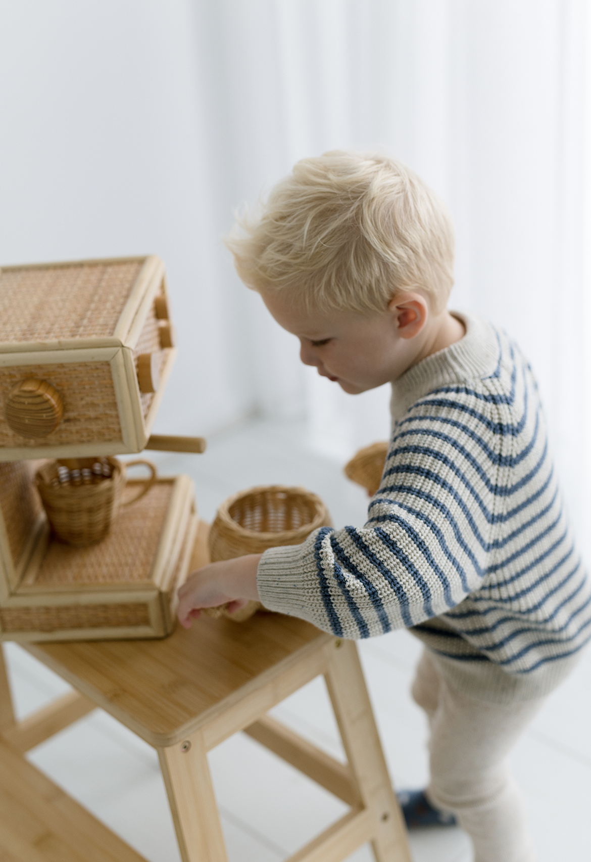 Child playing in striped knit jumper