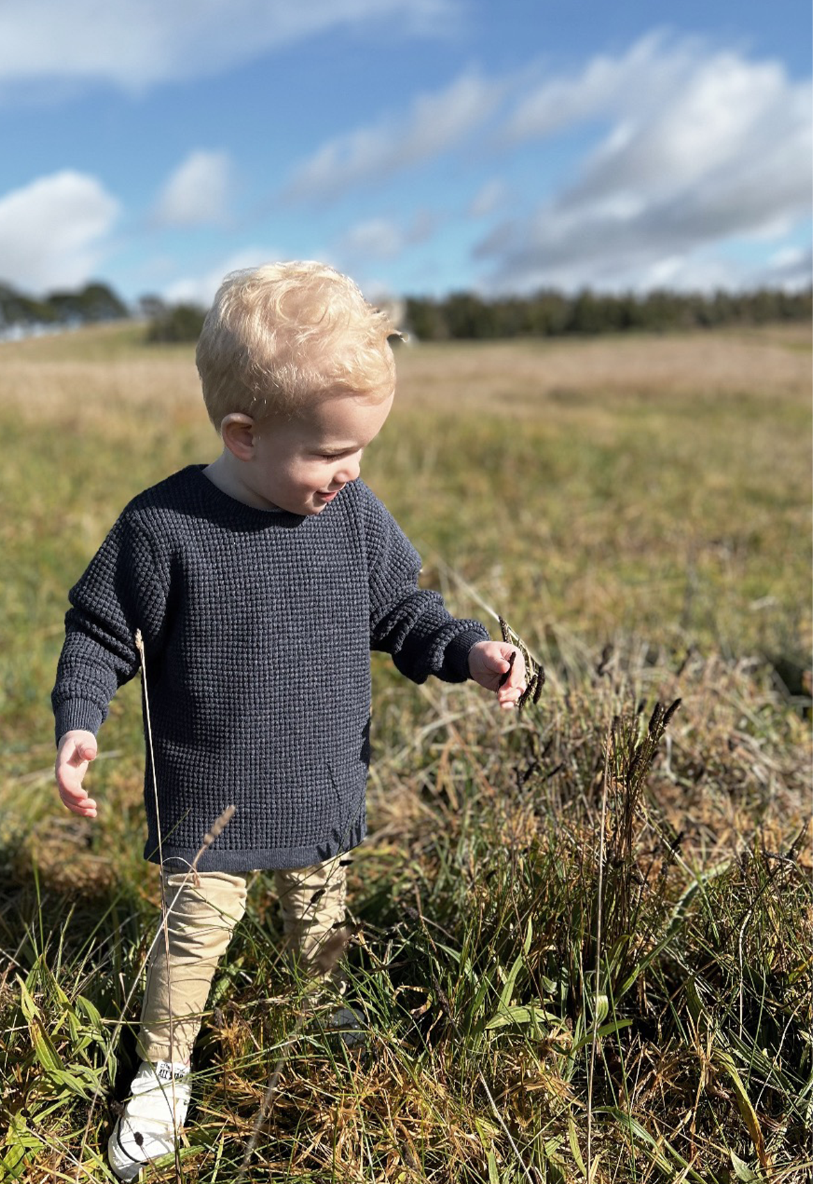 transeasonal lightweight jumper, toddler picking flower in knit jumper matched with chinos