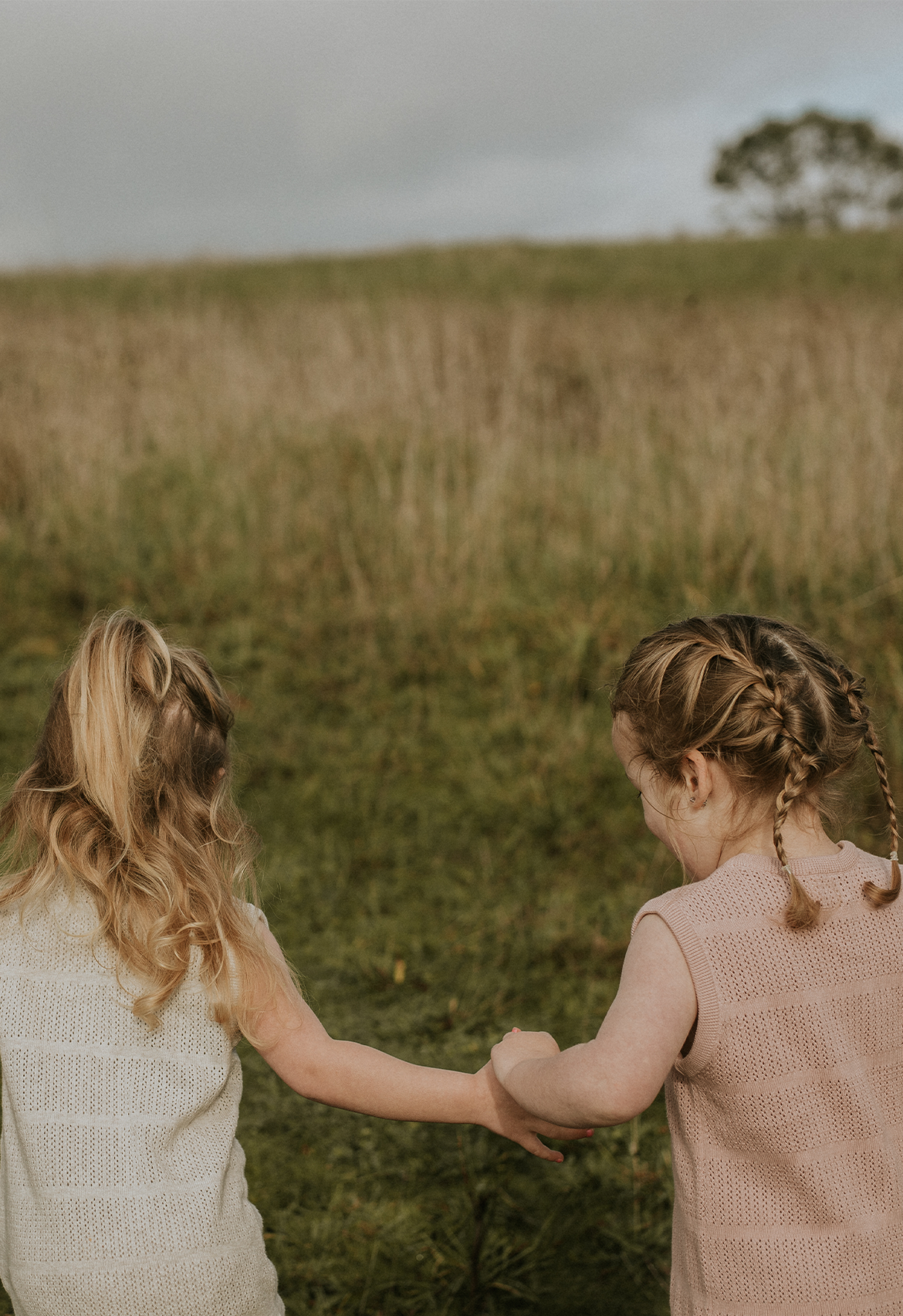 two girls in pointelle dress in field paddock