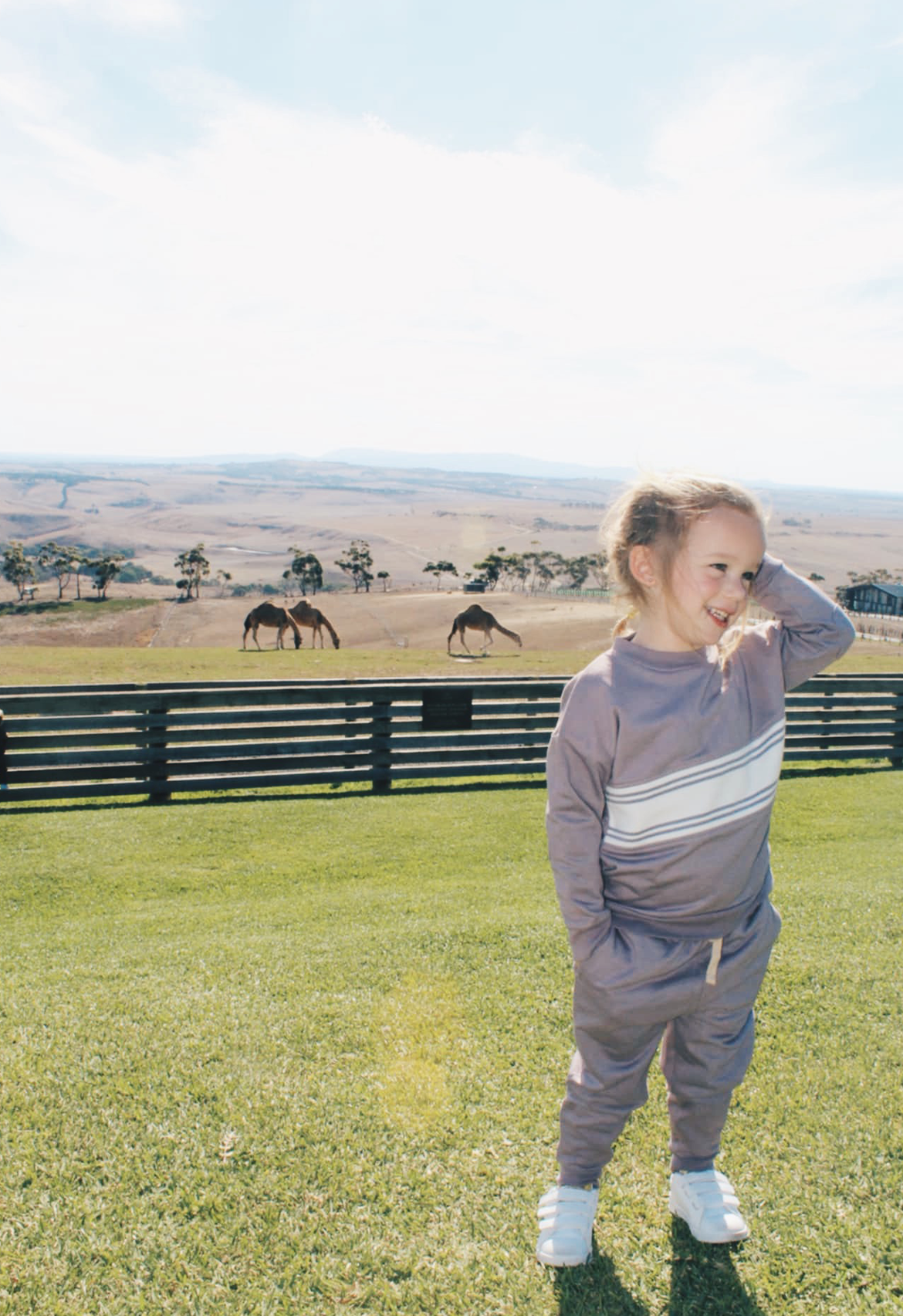 girl wearing dusty purple matching tracksuit with camels in background