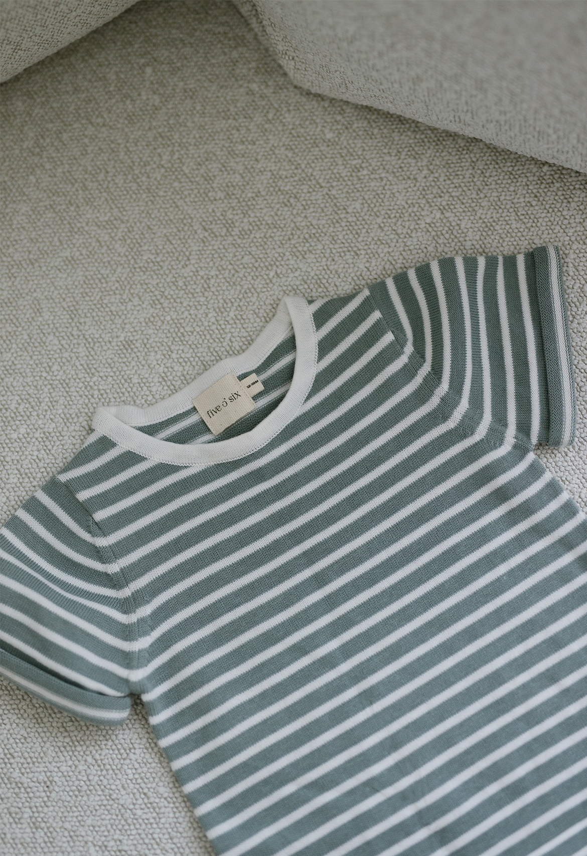 teal and white striped knit t shirt flat lay
