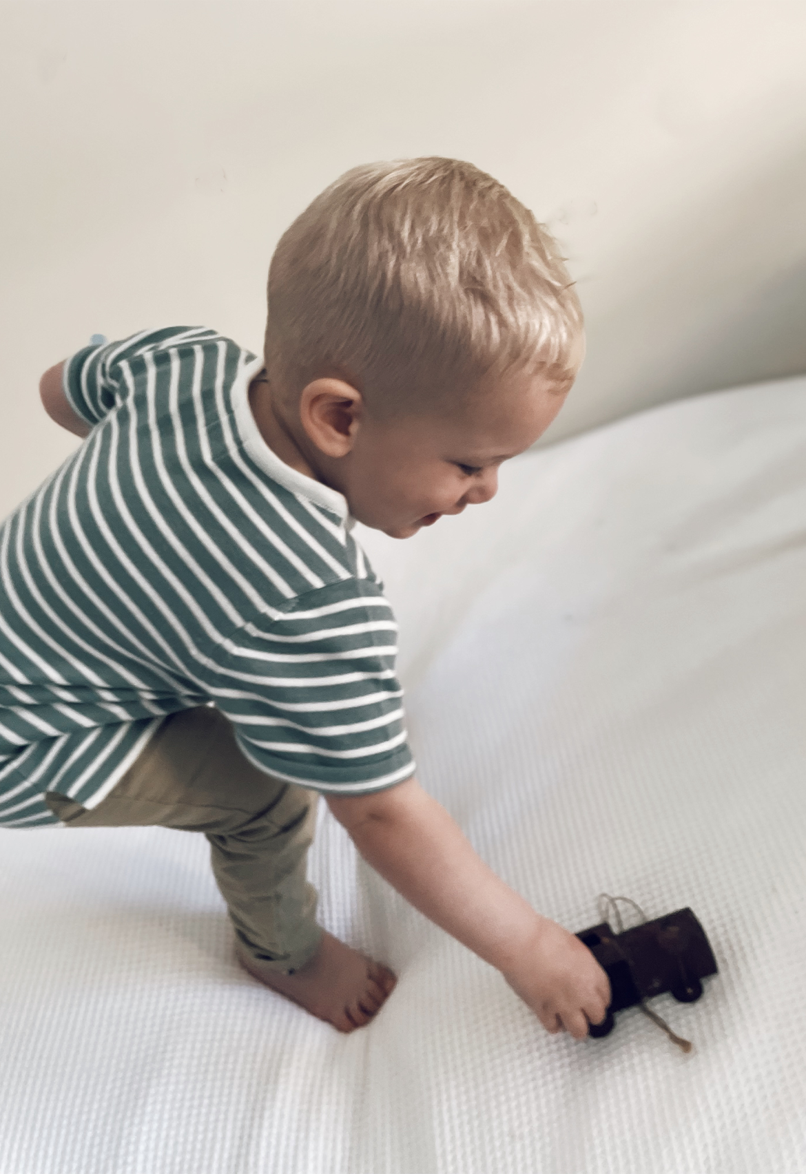 child playing with cars in knit tee