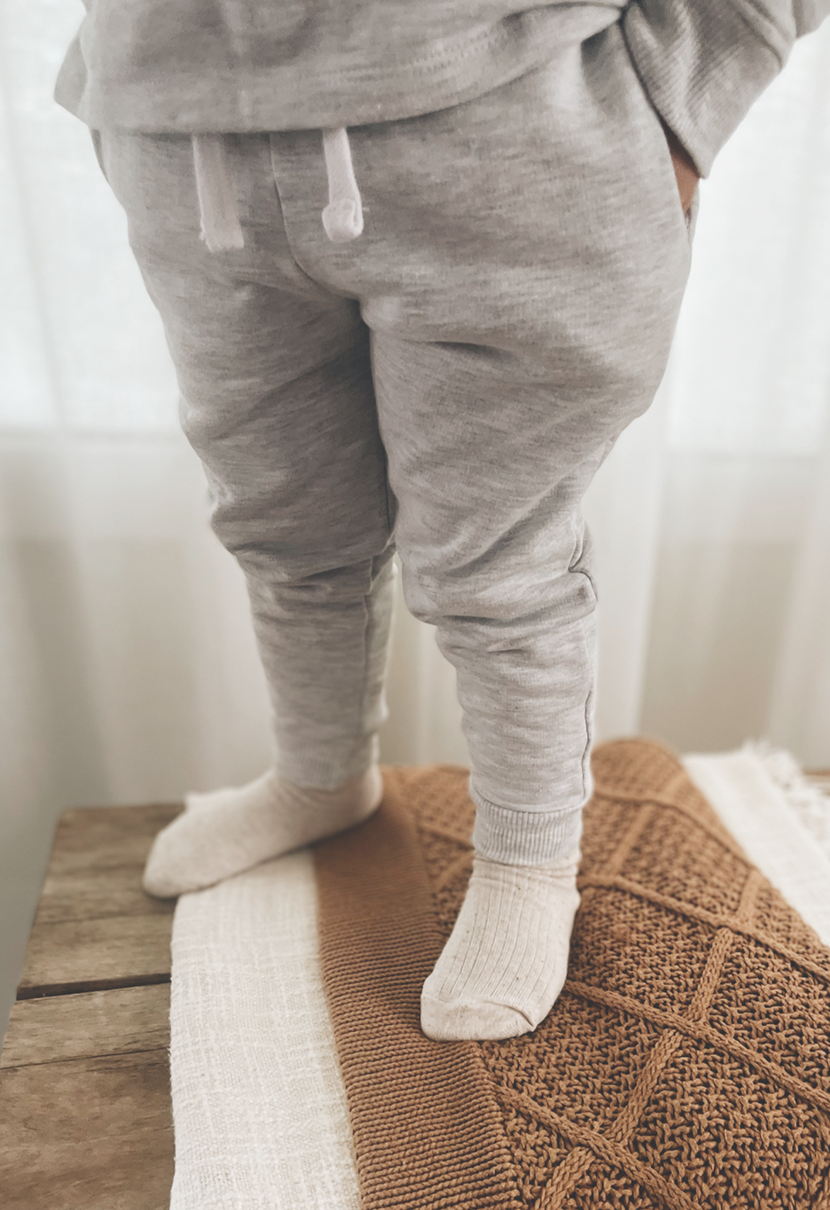A pair of marle grey lounge tracksuit pants with a white drawstring.